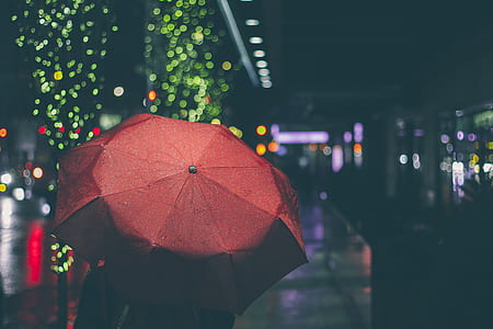 person using red umbrella during nighttime thumbnail