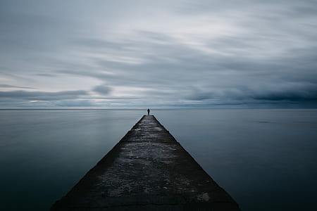 person on dock near body of water thumbnail