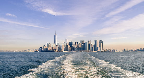 cityscape photo of city between blue sky and body of water thumbnail