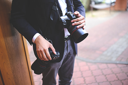 man standing while holding DSLR camera thumbnail