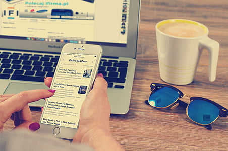 person using iPhone near MacBook Air thumbnail