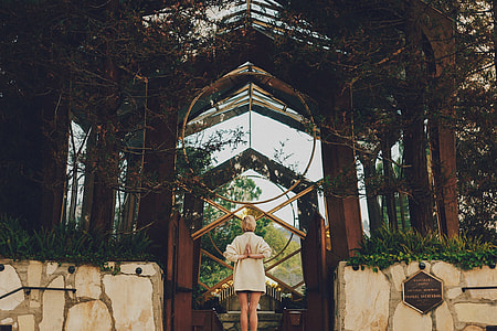woman standing in front of wooden arch thumbnail