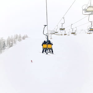 two people sitting on ski lift during daytime thumbnail