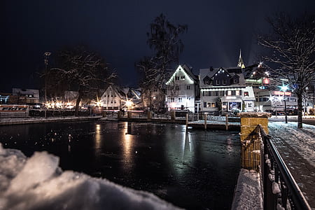 Body of Water Infront of White 3-storey Houses during Night Time thumbnail