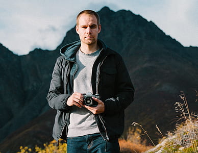 man in black zip-up hoodie holding camera thumbnail