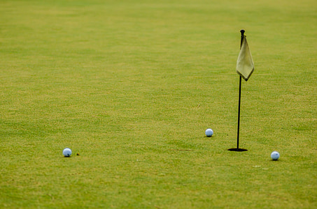 three golf balls on green grass at daytime thumbnail