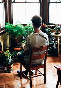 man sitting in front of leafed plants thumbnail