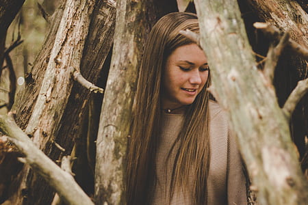 women in gray sweater standing near tree thumbnail