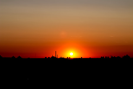 silhouette of buildings under orange sky during golden hour thumbnail