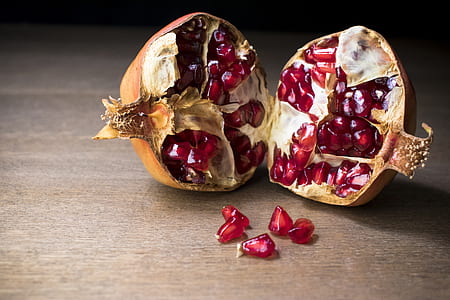 brown and red pomegranate on brown wooden surface thumbnail