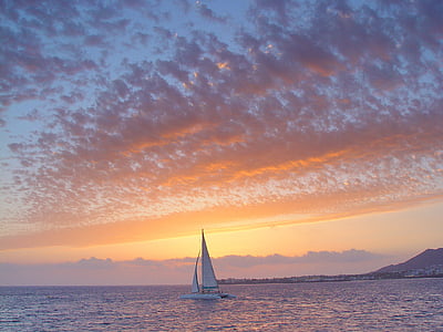 white sailboat on body of water under alto cirrus clouds thumbnail