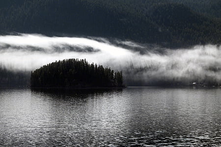 silhouette photo of island surrounded with fogs thumbnail