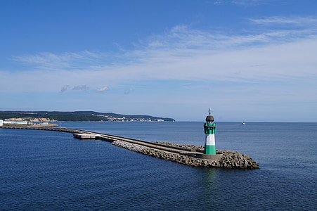 green and white lighthouse surrounded by ocean during daytime thumbnail