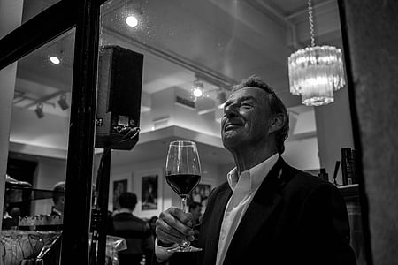 grayscale photo of man holding wine glass thumbnail