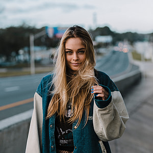 shallow focus photography of a woman in blue and gray jacket thumbnail