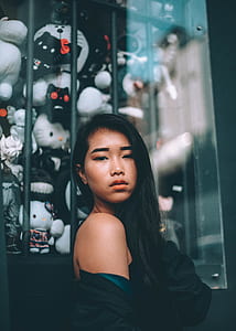 woman poses near glass window displaying plush toys thumbnail