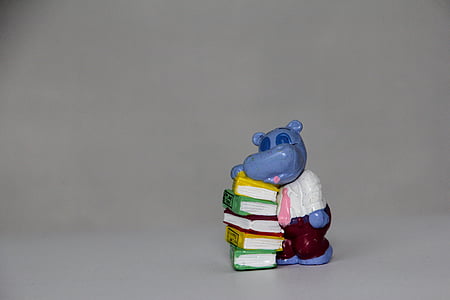 Hippopotamus and books figurine on white surface thumbnail