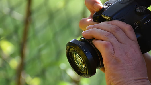 person holding black Sony DSLR camera thumbnail