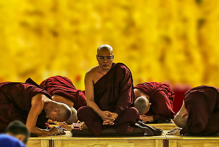 monk bowing their heads in front of meditating monk close up photography thumbnail
