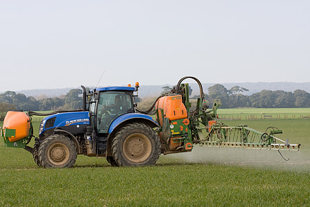 blue and yellow tractor on grass field thumbnail