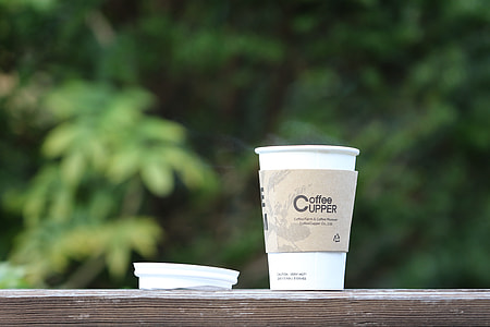 selective focus photography of white Coffee Upper disposable cup on table thumbnail