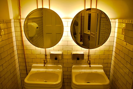 two round gray metal framed wall mirrors and sinks on bathroom thumbnail
