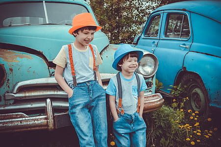 two boys smiling while leaning on vintage car thumbnail