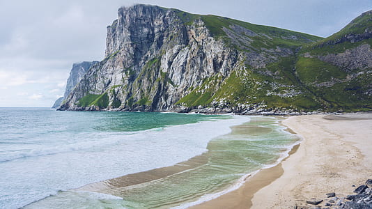 mountain near beach at daytime thumbnail