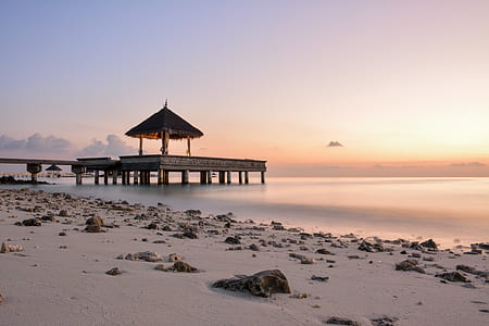 wooden hut on dock at beach during daytime thumbnail