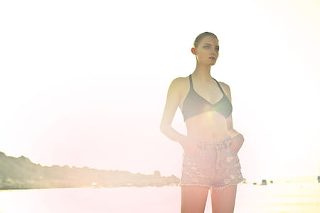 oung Woman Posing In Black Bra And Jean Denim Shorts During Photo Shoot At Beach thumbnail