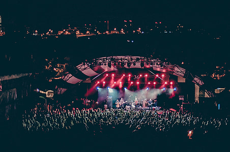male bands performing on stage infront of people during nighttime thumbnail