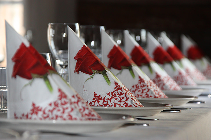 white-and-red rose graphic paper towel on arrange plate placed on table