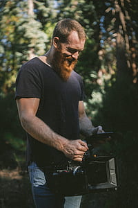 person wearing black shirt holding professional camera smiling thumbnail