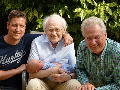 three men taking picture with a baby during daytime thumbnail