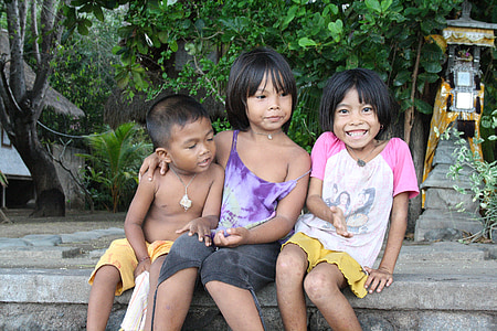three children sitting on ledge near plants thumbnail