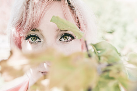 photo of a woman behind the leaves during daytime thumbnail