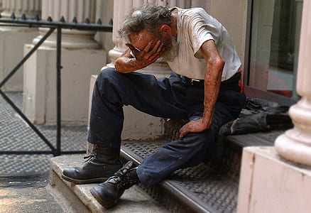 man sitting on floor beside glass door thumbnail