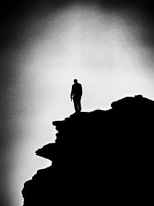 grayscale photo of a man on the top of mountain thumbnail
