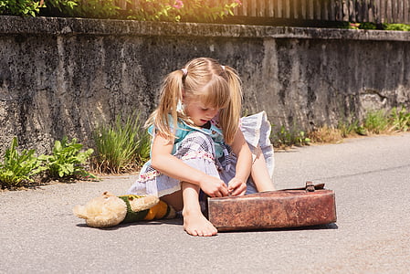 blonde haired girl seating in road holding brown leather bag thumbnail