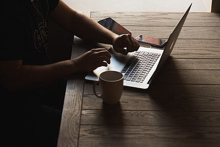 person sitting on chair in front of MacBook on table thumbnail