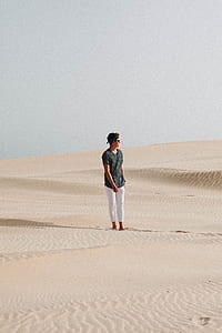 man standing on desert under gray sky thumbnail
