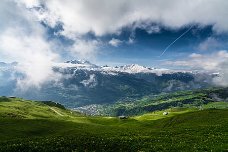landscape photo of a green mountain peak under cloudy sky thumbnail