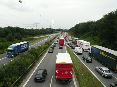 cars and trucks on busy road thumbnail
