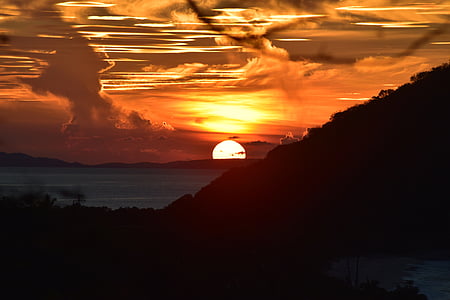 silhouette of hill under cloudy sky photo taken during sunset thumbnail