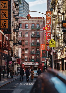 crowd of people walking on road between buildings thumbnail