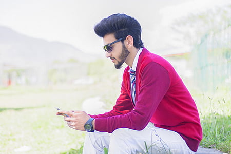 man in red vest holding phone wearing sunglasses thumbnail
