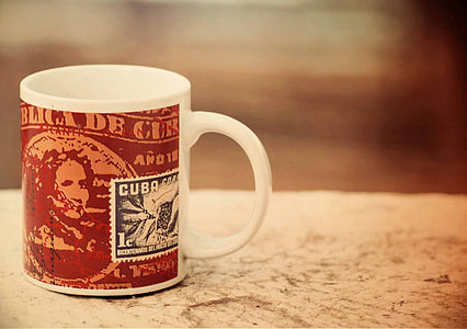 white and red ceramic mug on top of white wooden table top thumbnail