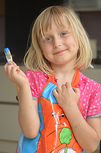 girl holding paintbrush with blue paint thumbnail