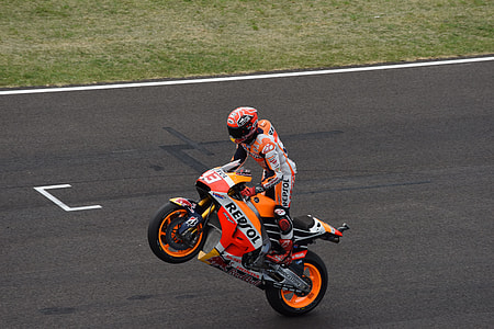 person wearing racing jumpsuit while riding sportbike during daytime thumbnail