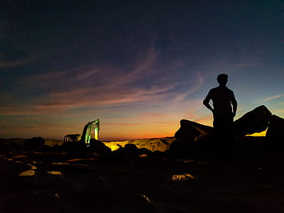 Silhouette Photo of Person Standing Near the Rock thumbnail